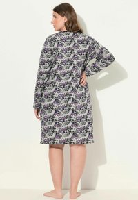Un camicione lungo a maniche, fino al ginocchio, realizzato in tessuto morbido, con un motivo floreale in tonalità di viola, nero e grigio. Progettato con una vestibilità comoda.