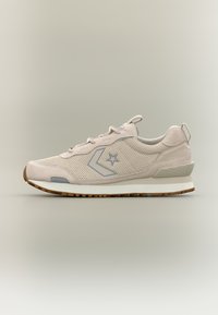 Μπεζ αθλητικό παπούτσι χαμηλού προφίλ με λεπτομέρειες από δίχτυ και σουέντ, γκρι αστέρι και λογότυπο σε σχήμα έβρου στην πλευρά, λευκή ενδιάμεση σόλα και καφέ καουτσούκ εξωτερική σόλα.