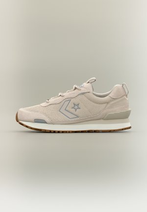 Beige lavtstående sneaker med mesh- og semsket skinn-detaljer, grå stjerne og chevronlogo på siden, hvit mellomsåle og brun gummiyttersåle.