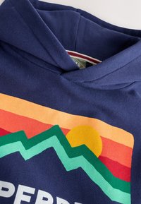 Navy blue hooded sweatshirt featuring vibrant mountain and sunset graphic in red, orange, green, and yellow. Soft cotton material.