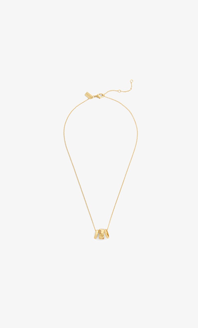 Collar de cadena de oro con tres colgantes circulares de oro, uno grabado con un diseño de luna creciente y estrella, sobre un fondo blanco.