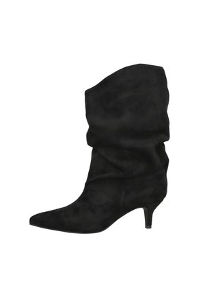Bota holgada de ante negro hasta la media pantorrilla, con punta puntiaguda y tacón bajo estilo kitten sobre fondo blanco.