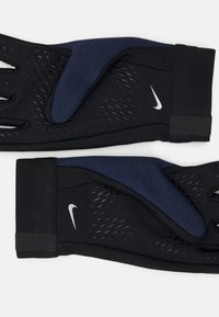 Gants d'entraînement noirs et navy avec une surface texturée, design sans doigts, et un logo Nike argenté au niveau du poignet.