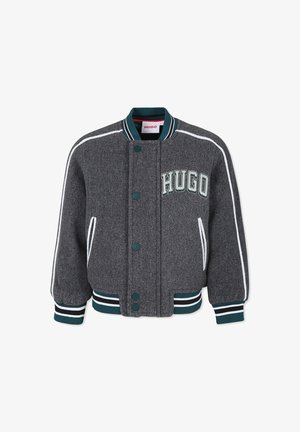 Veste bomber en laine grise avec des accents blancs et verts, boutons sur le devant, poignets côtelés et "HUGO" brodé sur la poitrine.