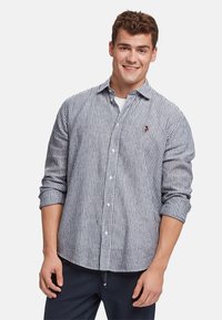 Camicia button-up a strisce blu e bianche, maniche lunghe arrotolate, in cotone, con un piccolo logo sul petto.