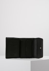 Zwarte leren portemonnee opent om verschillende kaartsleuven, een compartiment voor biljetten en een drukknoopsluiting te onthullen. Gestructuurafwerking overal.