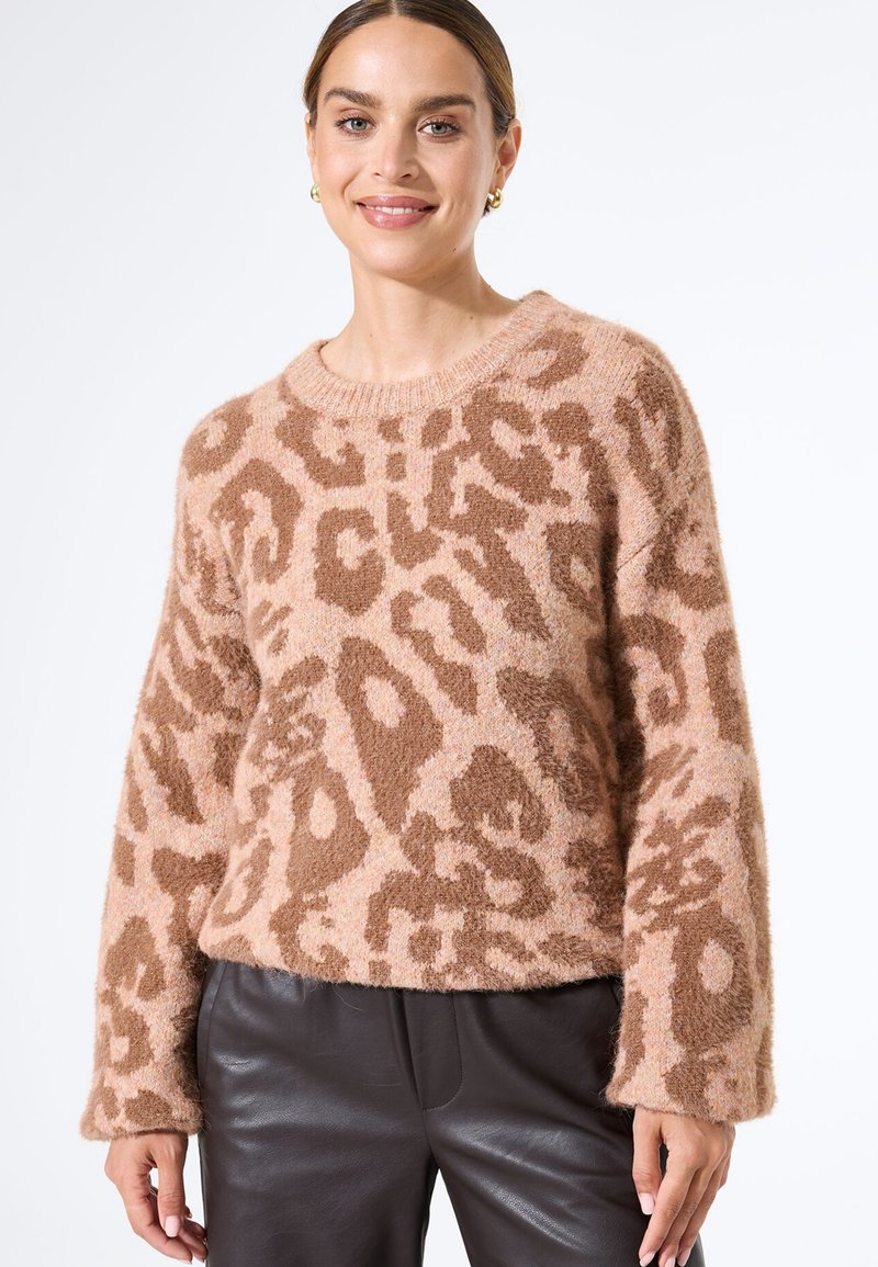 Fluffy, pink Leopardenmuster-Pullover mit rundem Ausschnitt und langen Ärmeln, kombiniert mit dunklen Lederhosen. Weicher Stoff und entspannter Schnitt.
