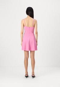 Ροζ αμάνικο φόρεμα με εφαρμοστό bodice και φουσκωτή φούστα. Διαθέτει κλείσιμο με φερμουάρ στην πλάτη και ρυθμιζόμενους ιμάντες τύπου spaghetti.