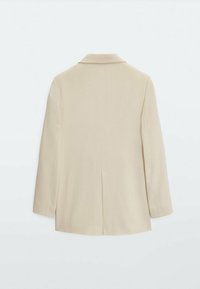 Vaaleanbeige räätälöity bleiseri, jossa on viistottu kaulus, pitkät hihat ja keskilänttä. Sujuva pinta ja minimalistinen muotoilu ilman näkyviä suljettavia osia.