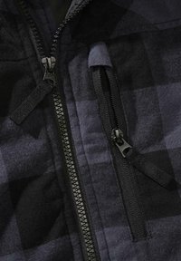 Crni i mornarski tartan s teksturiranim završetkom; sadrži džep sa patentnim zatvaračem i kontrastne crne patentne zatvarače na dizajnu jakne.