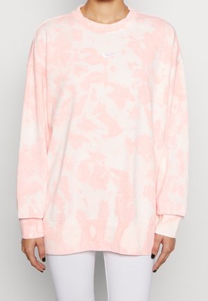 Lichtroze tie-dye sweatshirt gemaakt van zachte stof, met lange mouwen, een ronde hals en een klein wit Nike-logo op de borst.
