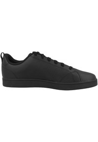 Scarpa sportiva nera con tomaia in sintetico liscia, design con lacci e dettagli laterali perforati. Suola piatta in gomma offre stabilità e aderenza.