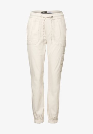 Pantaloni in cotone beige chiaro misto con vita elasticizzata, dettaglio con cordino, tasche laterali e polsini elasticizzati alla caviglia.