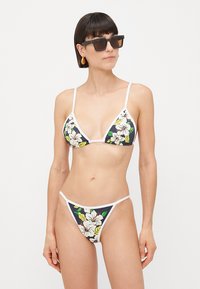 Bikini set with a navy floral print and white trim. Features triangular cups and a low-rise bottom. Material appears smooth and stretchy.