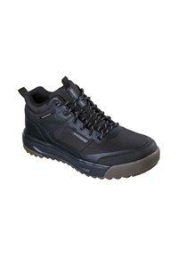 Zapato de senderismo negro impermeable con parte superior texturizada, diseño con cordones, lengüeta para tirar y suela robusta para tracción en superficies variadas.