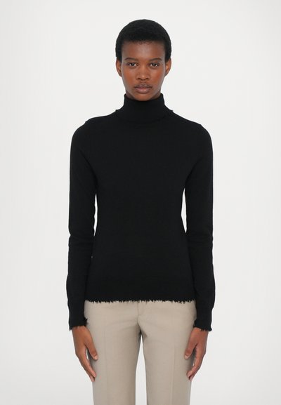 Schwarzer Rollkragenpullover mit langen Ärmeln und ausgefranstem Saum, aus einem weichen Material gefertigt. Getragen mit hellbeigen Hosen.