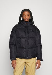 Black puffer jacket with a high collar, zip closure, and subtle logo detail. Features a puffy quilted design and smooth texture.