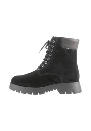 Bottine à lacets en cuir suédé noir avec semelle en caoutchouc épaisse et col en cuir rembourré, arborant une étiquette imperméable Gore-Tex sur le côté.