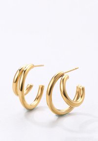 Goldene Creolenohrringe mit einem Doppelring-Design und polierter Oberfläche. Die Form ist kreisförmig mit glatten Kanten und einer minimalistischen Ästhetik.