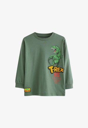 T-shirt verde a maniche lunghe con grafica di un T-Rex in verde e giallo, con testo rosso che recita "65 MILIONI DI ANNI FA" e una patch con logo.