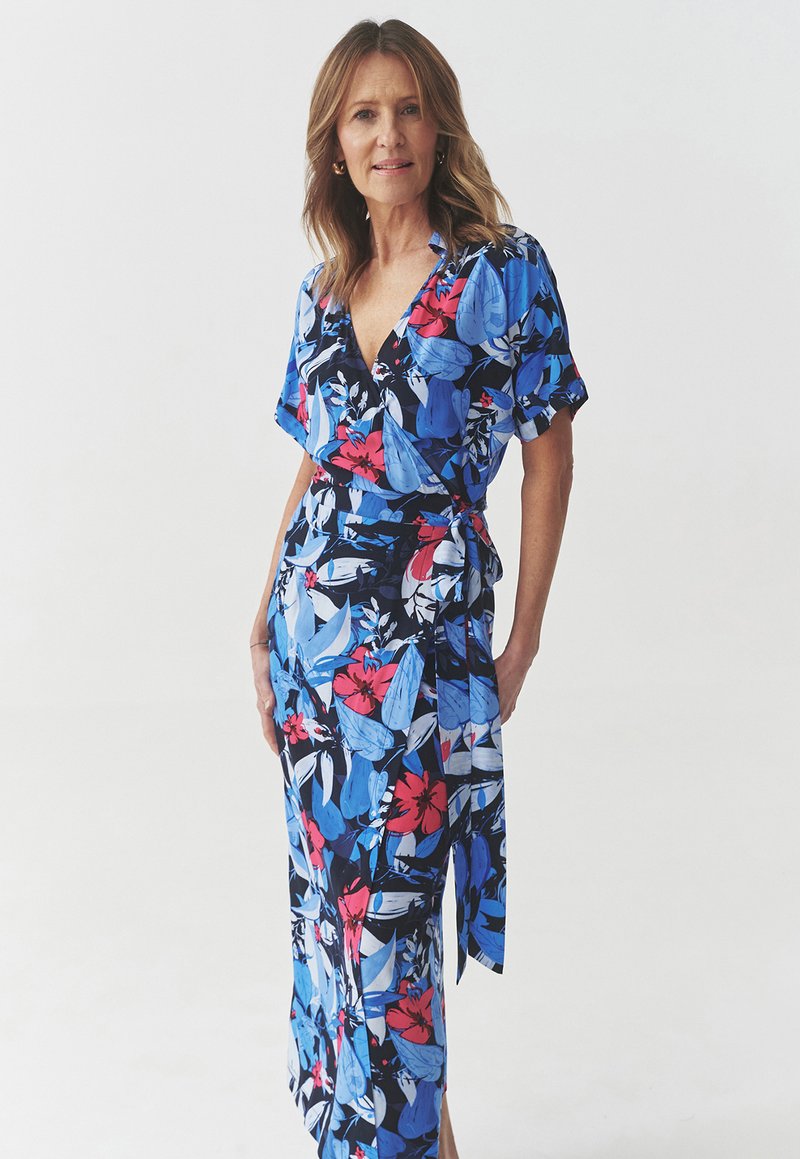 Rochie florală înfășurată cu mâneci scurte, având o bază vibrantă de culoare albastră cu flori roz și albe. Material moale, design până la gleznă cu talie legată.