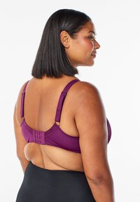 Violet krūšturis ar regulējamām siksnām un āķa aizdari. Gluda auduma, zema muguras konstrukcija un smalkas detaļas siksnās.