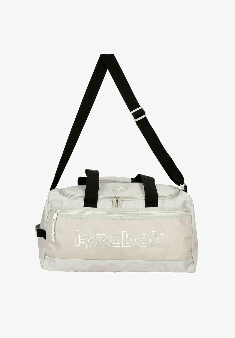 Bolsa de lona Reebok gris clara con correa de hombro negra ajustable y dos asas negras, bolsillo delantero con cremallera y cierre principal de cremallera.