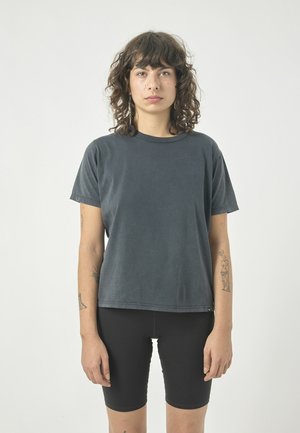 Dark grey cotton t-shirt with a crew neck and short sleeves, paired with black cycling shorts. Smooth texture, loose fit, minimal design.