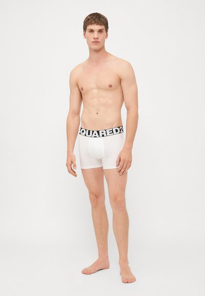 Weiße Baumwoll-Boxershorts mit einem dicken schwarzen Bund, auf dem "DSQUARED2" in fetten weißen Buchstaben steht. Für Komfort und Passform entworfen.