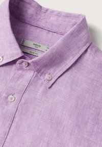 Chemise en lin lavande à coupe ajustée, col boutonné, et boutons clairs. Tissu texturé avec un motif de tissage subtil.