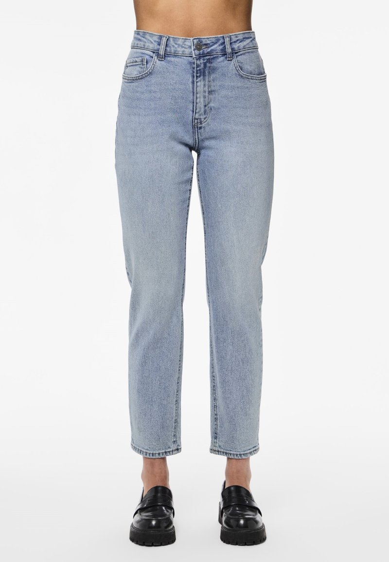 Jean bleu clair taille haute avec une coupe droite. Comprend des poches avant et une fermeture à bouton. Le matériau présente une légère décoloration et texture.