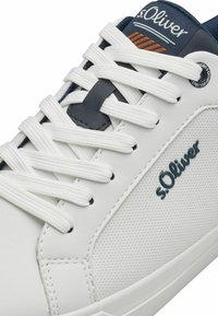 Weiße Sneakers aus strukturiertem Synthetikmaterial, mit marineblauen und orangen Akzenten, flachen Schnürsenkeln und einem Logo an der Seite. Geschmeidiges, abgerundetes Design.