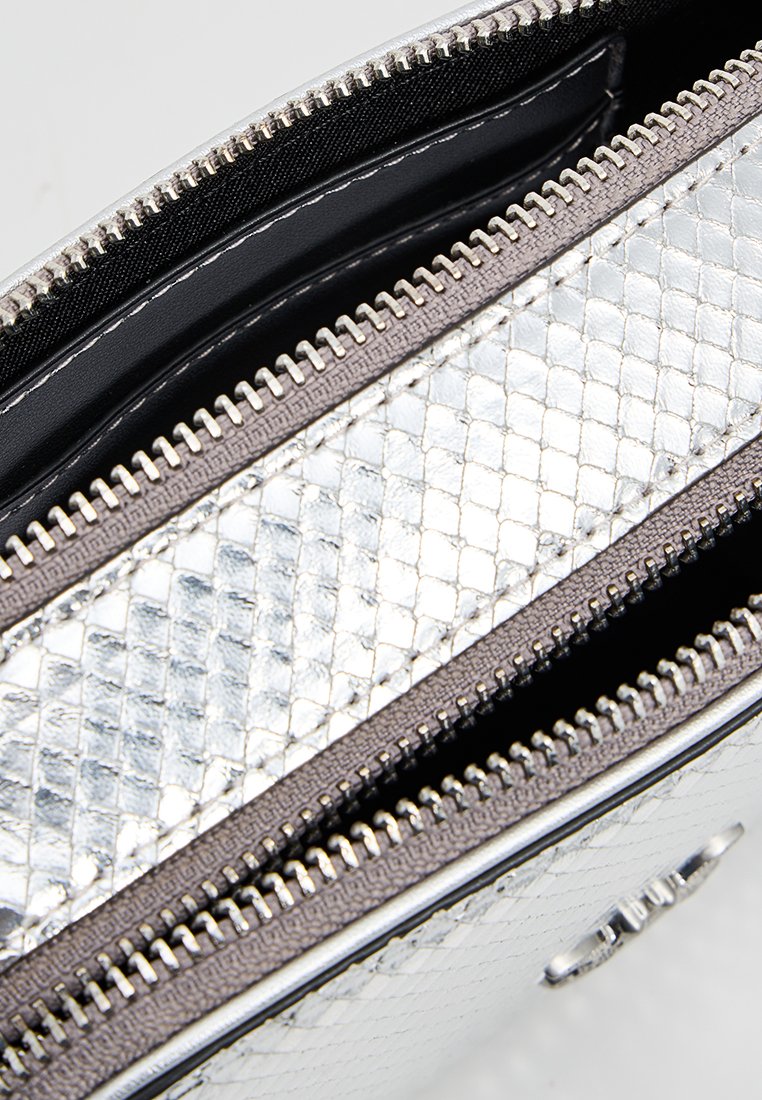 Srebrna torebka na zamek błyskawiczny z teksturowanym, błyszczącym wykończeniem i wzorzystą powierzchnią oraz czarnym wnętrzem. Dwie przegrody do organizacji.