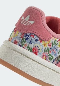 Růžová semišová patní část s květinovým vyšívaným vzorem v různých barvách, bílá strukturovaná gumová podrážka a třípruhové logo ve stříbrné barvě.