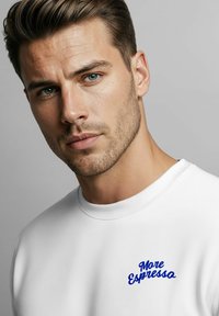 Weißes Sweatshirt mit Rundhalsausschnitt und geripptem Kragen, mit blauem gesticktem Text "More Espresso" auf der Vorderseite. Glatte Textur.