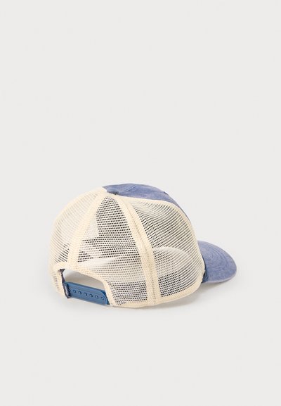 Κυανό και μπεζ trucker καπέλο από δίχτυ με ρυθμιζόμενο λουράκι snapback, απεικονίζεται από πίσω και τοποθετημένο σε απλή ανοιχτή επιφάνεια.
