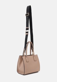 Beige strukturerad handväska med två ovandelar och ett avtagbart svart band med logotyp. Guld detaljer och slät textur.