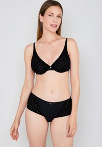Black lingerie set featuring a textured bra and high-waisted panties. Smooth fabric with a lace trim and subtle pattern details. Gold accent hardware.