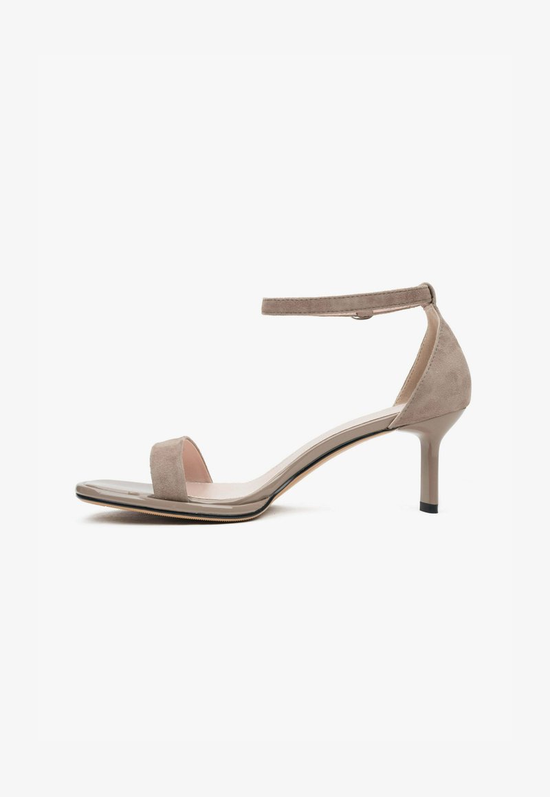 Beige suède hielsandalen met een enkelbandje, open teen, een glad leren voetbed en een slanke hoge hak. Minimalistisch ontwerp.