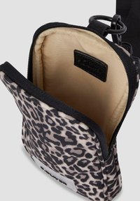 Borsa con stampa leopardata caratterizzata da una chiusura con cerniera, bordi neri e una foderatura interna beige. Include un'etichetta cucita nel tessuto.