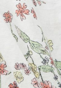 Tissu blanc avec un délicat motif floral comportant de petites fleurs et feuilles roses, jaunes et vertes sur des tiges fines.