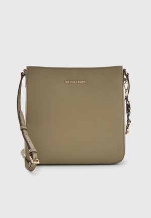 Zielonooliwkowa torebka Michael Kors na ramię z regulowanym paskiem i złotym logo z przodu, na jednolitym jasnym tle.