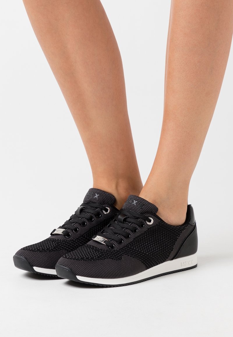 Svarta meshsneakers med en texturerad överdel, platta snören, metallisk ögla och en kontrasterande vit sula. Rundad tå och vadderad krage.