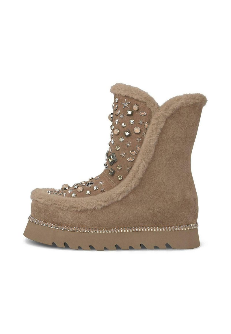 Bota de ante marrón con forro de piel sintética, adornada con tachuelas de diferentes formas y rhinestones. Cuenta con una suela en cuña y un ribete decorativo.