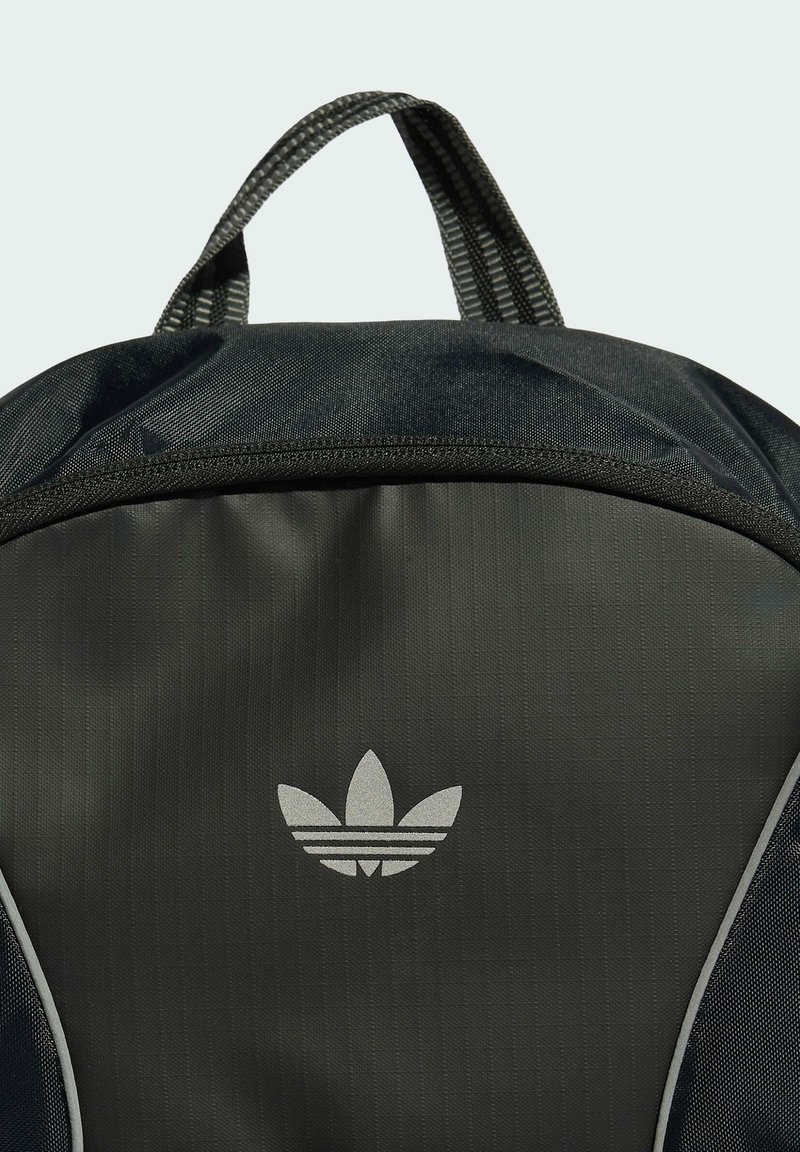 Schwarzer Adidas Rucksack mit Tragegriff, Frontreißverschlusstasche und weißem Trefoil-Logo mittig auf dem Frontpanel.