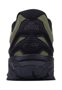 Baskets de sport noires et vert olive avec une tige en mesh, semelle en caoutchouc et un design de talon arrière bien prononcé. Présente le logo de la marque sur le talon.