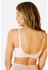 Jasnoróżowy miękki stanik z regulowanymi ramiączkami, zakrzywionym tyłem i zapięciem na haftkę. Gładka tekstura z minimalną ilością szwów.