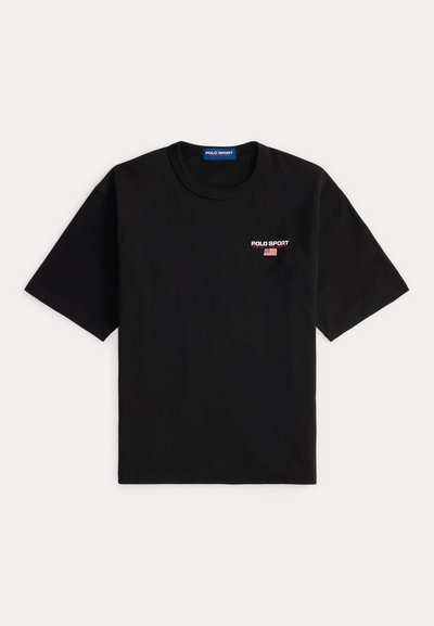 Camiseta negra de manga corta de algodón. Presenta el logotipo "POLO SPORT" en blanco y rojo, con un gráfico de la bandera estadounidense en el lado izquierdo del pecho.