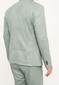 Jasnoszara marynarka garniturowa z fakturowanej tkaniny, z pojedynczym rozcięciem z tyłu oraz trzema guzikami na mankiecie. Dopasowany krój, nowoczesny design.