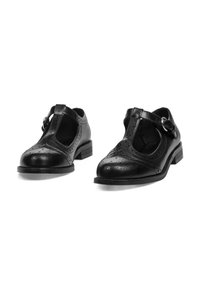 Zapatos de charol negros con detalle perforado, con puntera redondeada y tacón bajo cuadrado. Acentos de hebilla plateada en las correas.